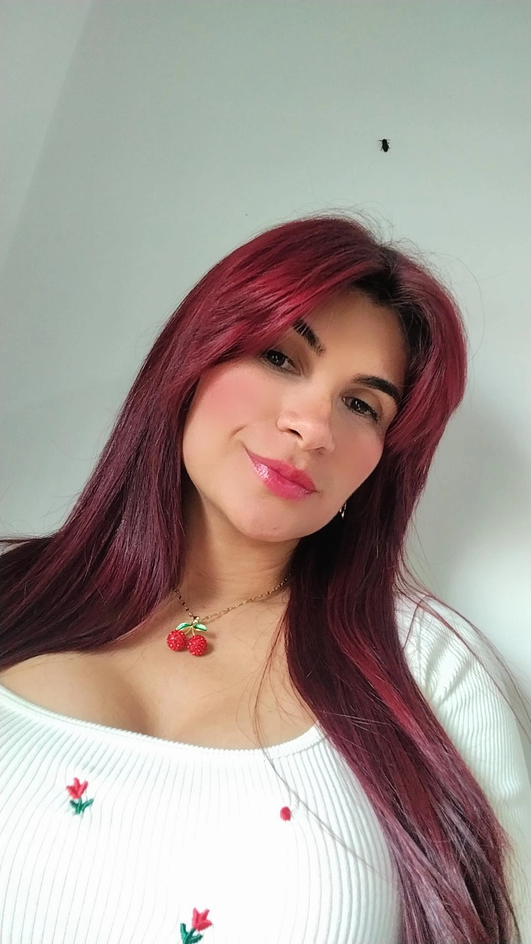 Woman with burgundy hair smiling at the camera